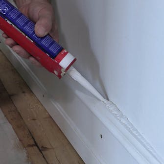 Iso rako seinän ja jalkalistan välissä: Levitä saumamassaa Iso rako seinän ja jalkalistan välissä: Levitä saumamassaa